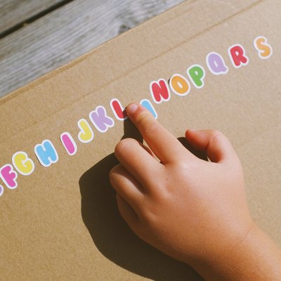 Child’s hand and alphabet stickers
