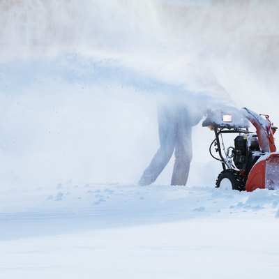 man with a snow blowing machine