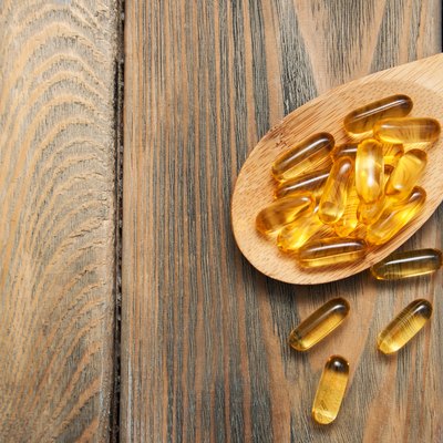 fish oil capsules in a spoon