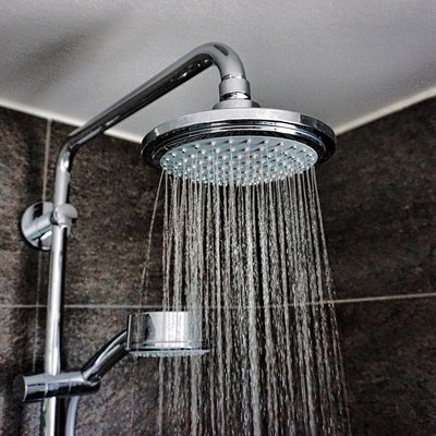 Close-Up Of Water Falling From Shower In Bathroom At Home