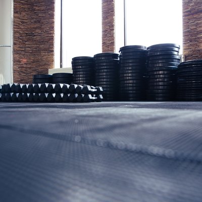 Ground view of a mat with weights and barbells in a gym