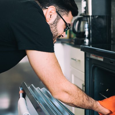 Man removing food from oven