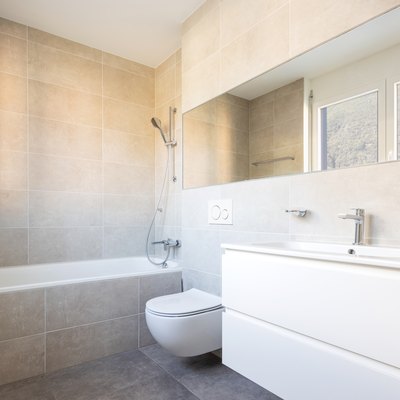 Modern minimal bathroom with large tile bathtub