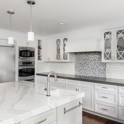 beautiful kitchen in new luxury home with island, pendant lights, and hardwood floors