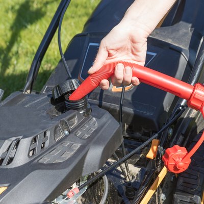 Pouring gasoline into lawn mower
