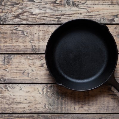 Traditional cast iron skillet pan on vintage wooden table