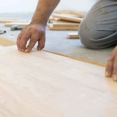 Carpenter lining up parquet-laminate plank