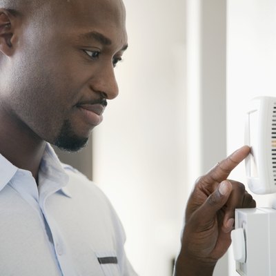 Man adjusting thermostat