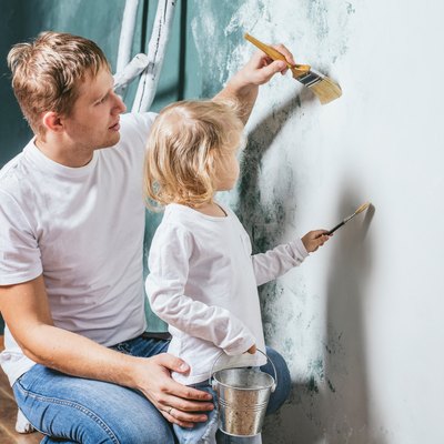 Family, happy daughter with dad doing home repair, paint walls,