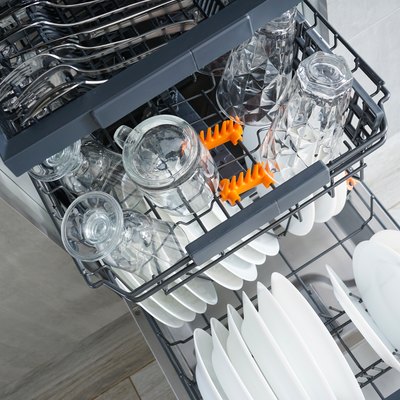 Dishwasher, open and loaded with dishes in the kitchen, after washing. Flat lay.