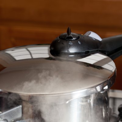 Pressure being released from cooker on hob