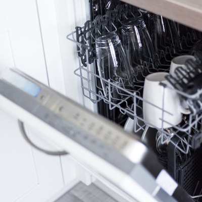 open dishwasher with clean glasses and dishes