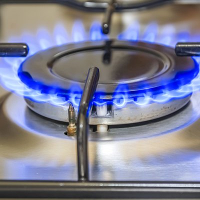 Close-up view of a kitchen cooker with blue flame