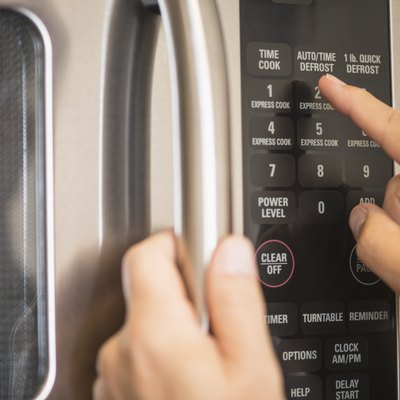USA, New Jersey, Jersey City, Close-up of hand using microwave oven