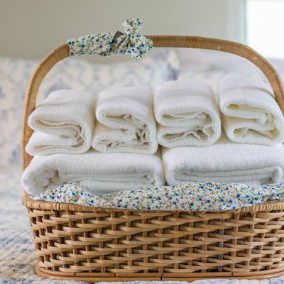 Close-Up Of Towels In Wicker Basket On Bed At Home