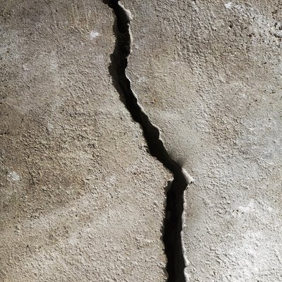 Close-up of a half-inch crack in a poured cement floor, background image