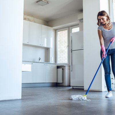 Young woman is doing cleaning of a laminate floor