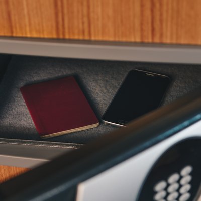 Close-Up Of Smart Phone And Passport In Safe