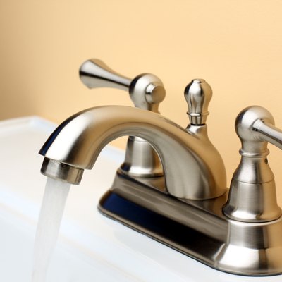 Water flowing from Brushed Nickel Faucet on Porcelain Bathroom Sink