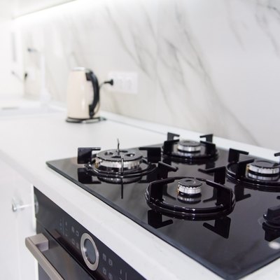 Modern high-tech black gas stove with sensor panel in the bright interior of the kitchen