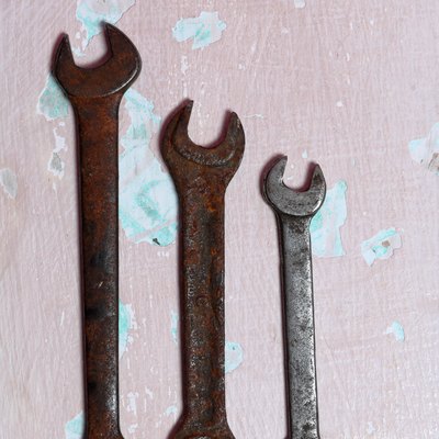 Wrenches for different sizes. Worn and covered with corrosion. Lie on the surface with peeling paint.