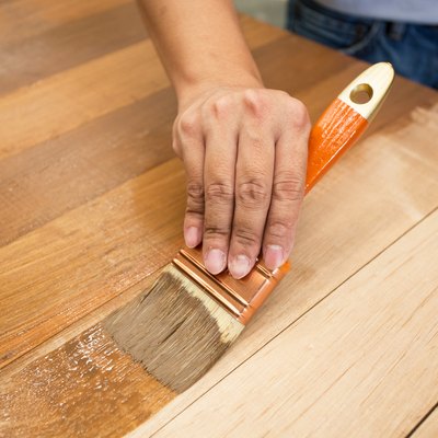 Applying protective varnish to wooden furniture.