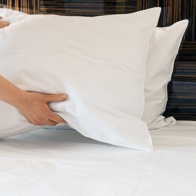 female hands corrected pillow on the bed