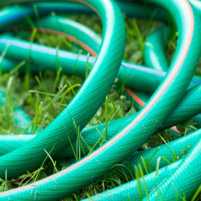 A green and orange hose for watering the garden close up