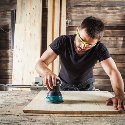 carpenter polishes wooden board