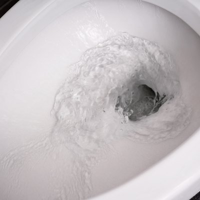 close up flushing water in toilet bowl.