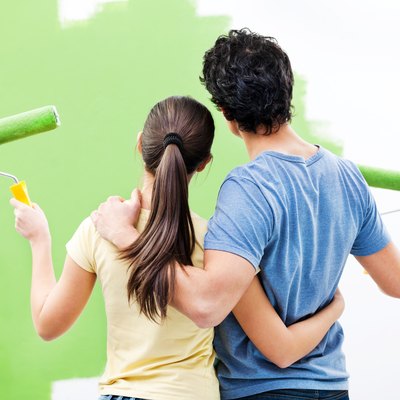 Young couple painting the wall.