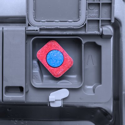A tablet of a detergent for washing dishes in dishwashing machine container