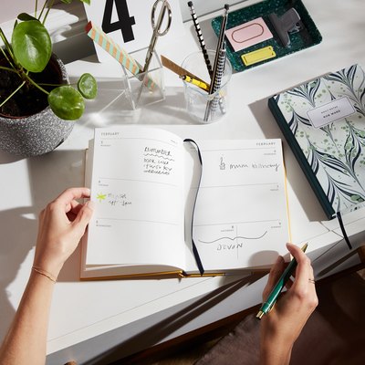 hands on open planner on desk