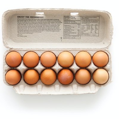 brown eggs in egg carton on white background