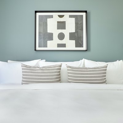 White bed against sage green wall