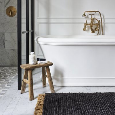 black rug in front of tub