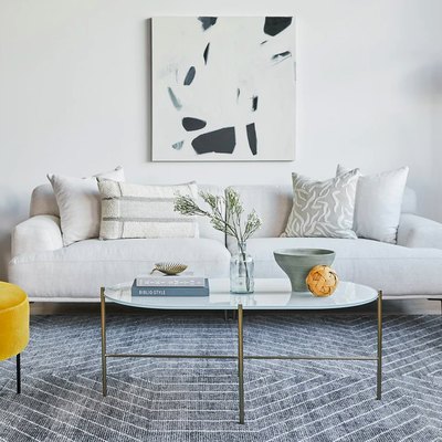 living room with white couch, gray rug, and white coffee table