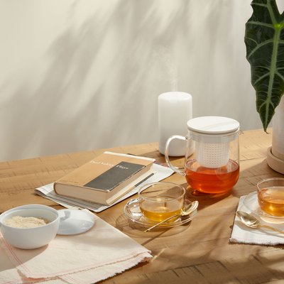 table with notebooks, plant, and tea accessories