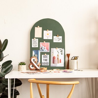 DIY Arched Mood Board sitting on white desk next to plant and bookshelf