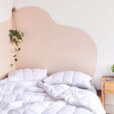 bedroom with white bedding and a wavy accent wall