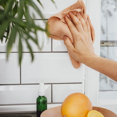 Cleaning kitchen tile with cloth, and lemons