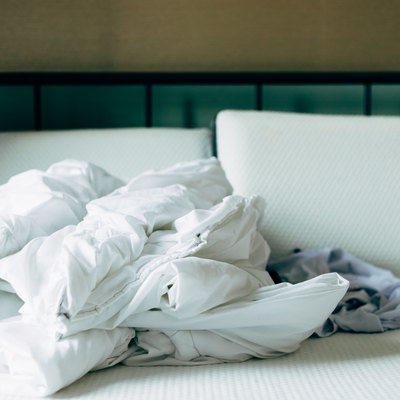 Duvet, and pillows on a bed without cover in a bedroom