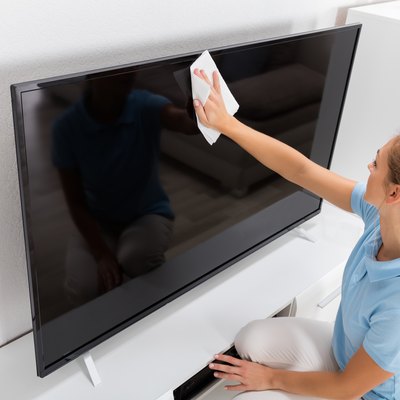 Woman Cleaning TV Screen