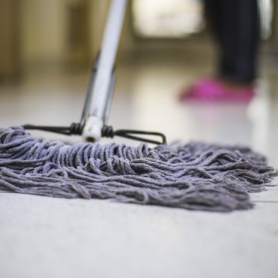 Low Section Of Person Cleaning Floor With Mop