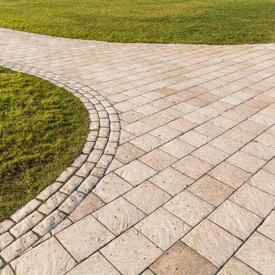 Curved path in the shape of a wave on the grass in a park. Pavers of different shapes.