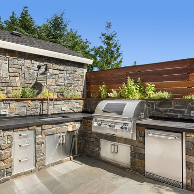 Backyard hardscape patio with outdoor barbecue and kitchen