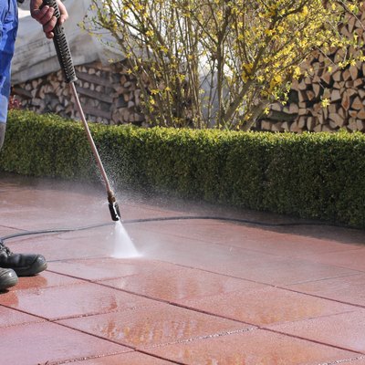 Cleaning patio pavers with power washer.