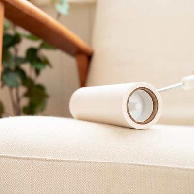 Cleaning sofa with lint roller.