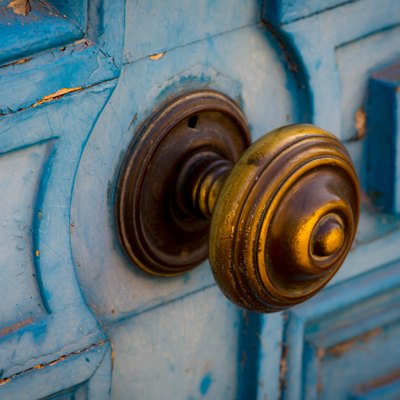 Old blue door with brass doorknob.