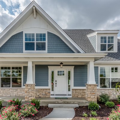 Home with blue siding and stone façade on base of home